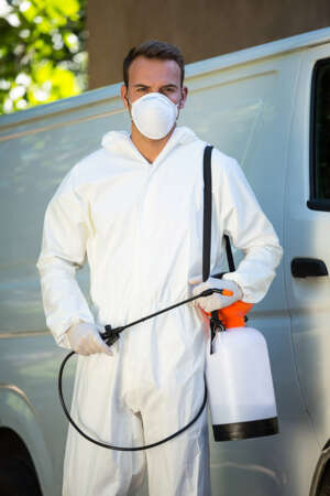 Portrait of pest control man standing next to a van on a street